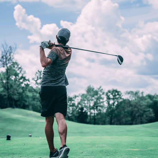 male golfer with golf club resting across back and shoulders after taking a swing