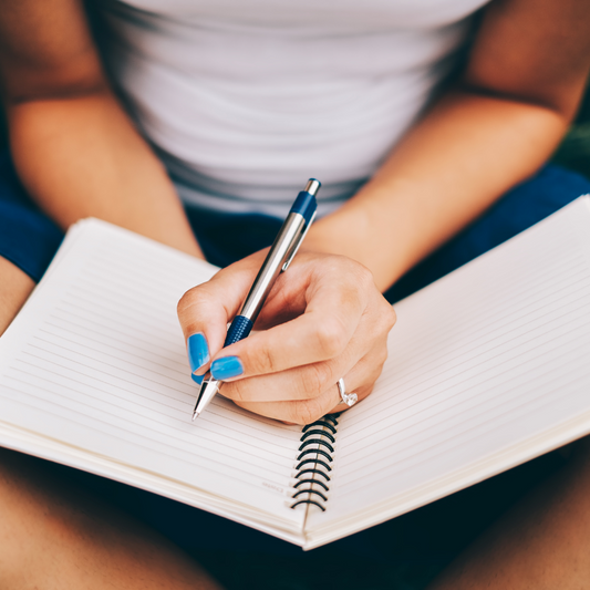 woman writing fitness goals into workout diary motivation 