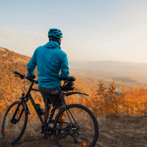 Health & wellness with U Perform - Man resting on his bike looking at a beautiful autumn view